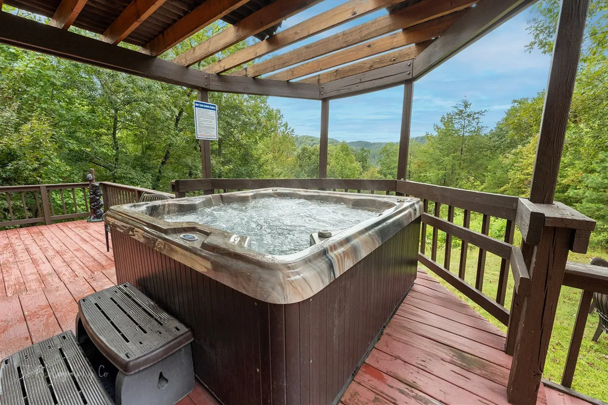 This image features a hot tub positioned on a wooden deck, offering expansive mountain views. The tranquil setting showcases the hot tub as a prime relaxation spot, with the natural landscape providing a serene backdrop, ideal for stargazing or soaking after a day of outdoor adventures.