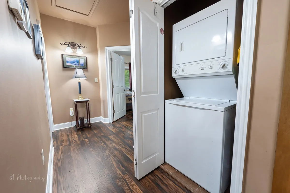 A practical interior view featuring a washer and dryer unit, a lamp, and a decorative picture, conveying the ease of in-unit laundry and the warmth of a well-appointed home.